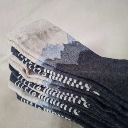 Stack of gray and beige mountain motif socks on a light background